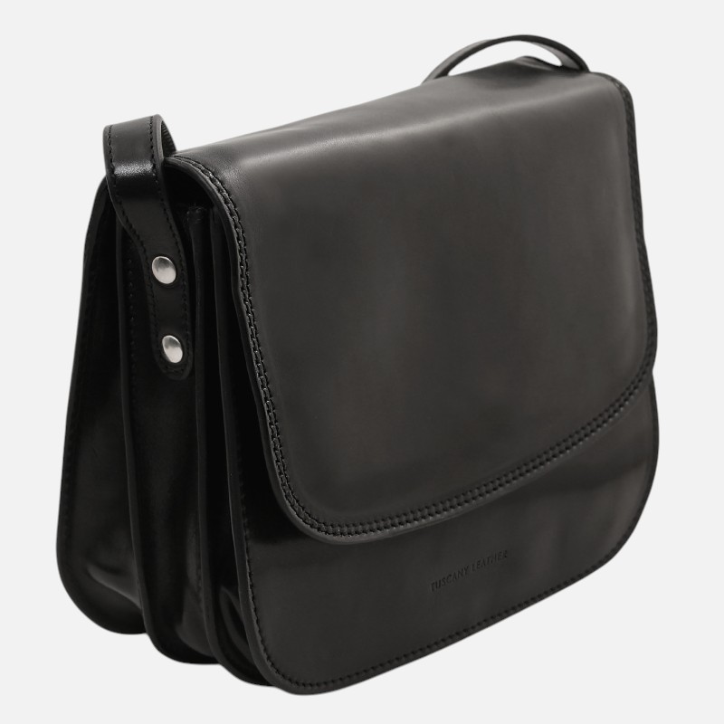 Black leather crossbody/messenger bag with a single flap and three compartments, Tuscany Leather branding visible on front edge.