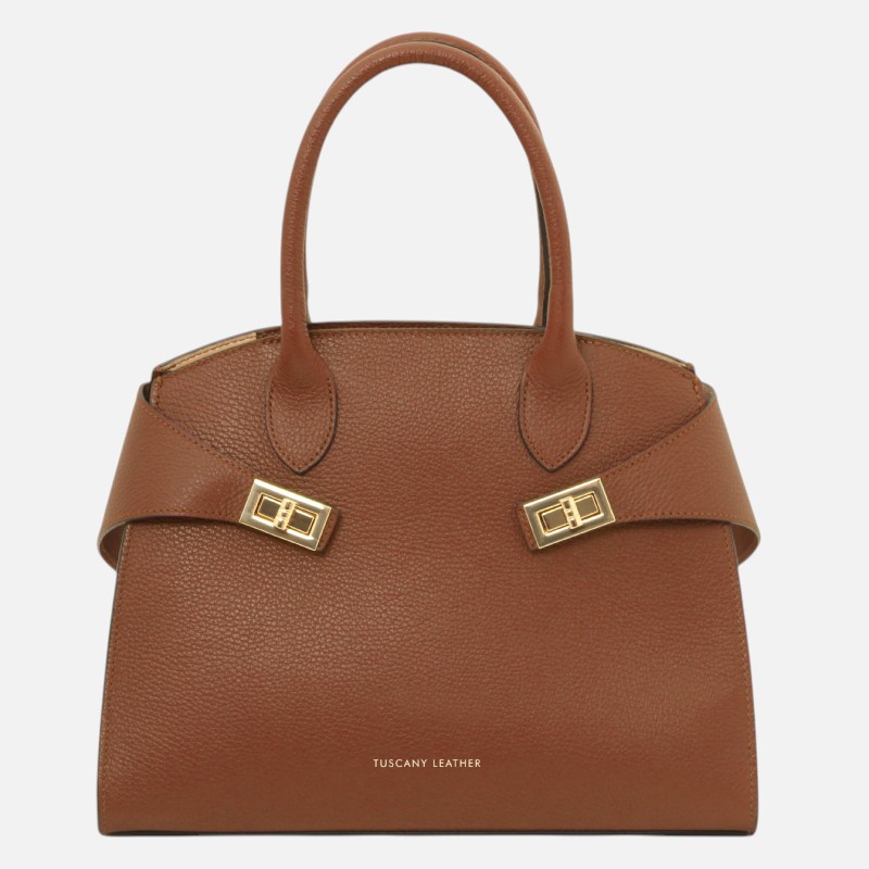 Brown pebbled leather handbag with two top handles and gold-tone buckle straps.