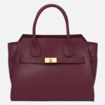 Maroon pebbled leather handbag with two top handles and a gold-tone clasp at the front center