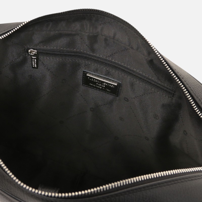 Interior of a black leather bag with a zippered pocket and a small brand label on the lining.