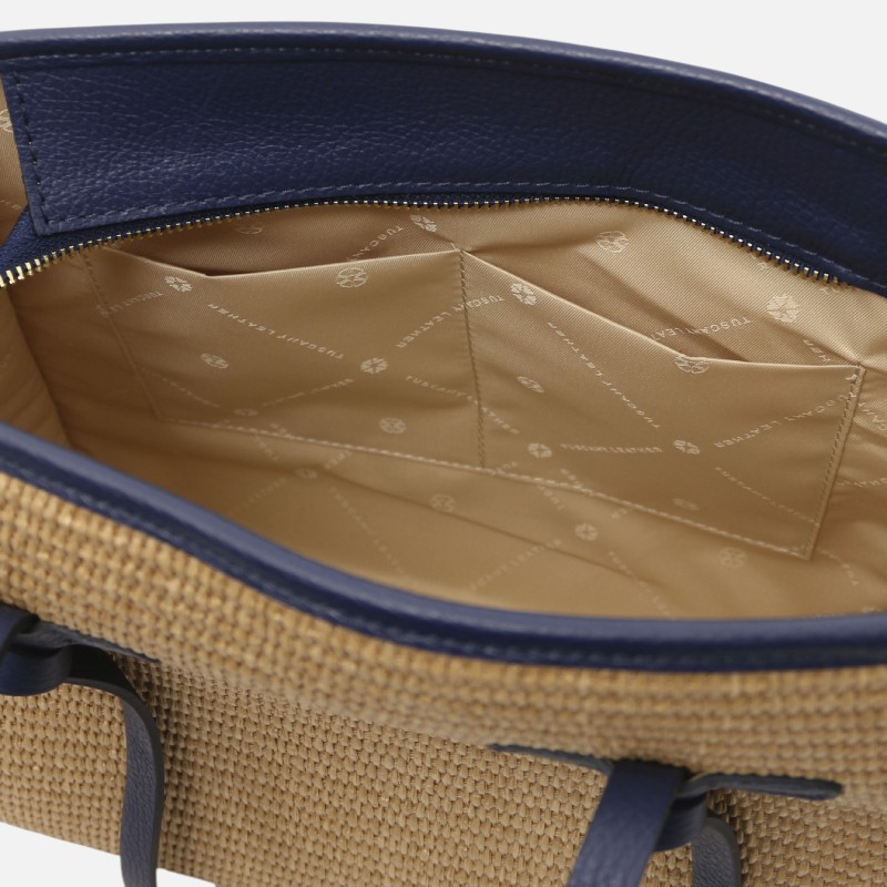 Interior view of a beige woven tote bag with blue trim, showing pockets and a patterned lining.