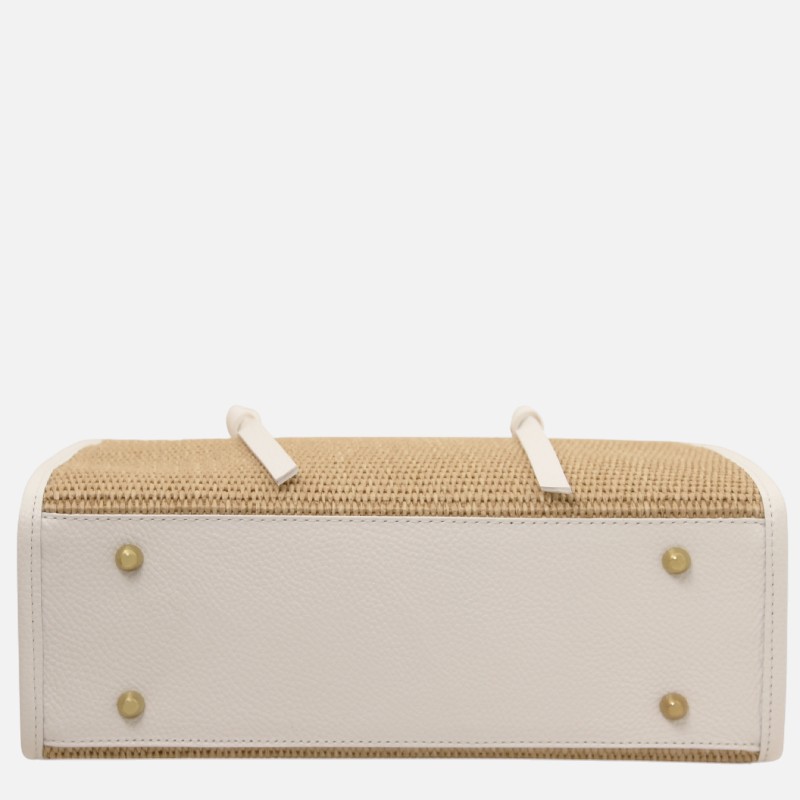 Bottom view of a two-tone handbag: white leather base with four gold studs and a straw-woven body, two small white straps on top