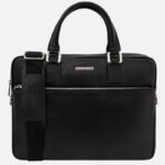 Black textured leather briefcase with two handles, a detachable shoulder strap, and a front zip pocket with silver hardware.