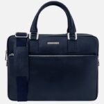 Navy blue leather briefcase with two top handles and a detachable shoulder strap, featuring a front zip pocket.
