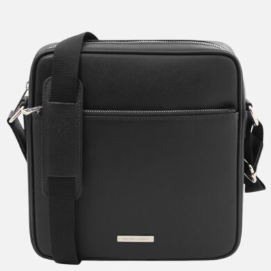 Black leather crossbody bag with a top zipper, front zip pocket, adjustable strap, and a small metal brand plate on the lower front.