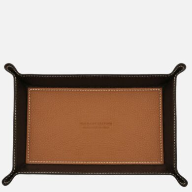 Two-tone leather tray: light tan center with a dark brown border and white stitching; embossed logo in the center.