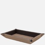Tan leather rectangular tray with dark brown interior and white stitching, for organizing small items at a desk or dresser.
