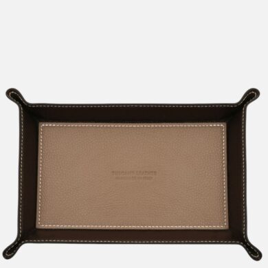 Rectangular tan leather tray with a dark brown rim and white stitching, embossed brand text in the center used as a catchall or display tray.