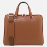 Brown leather briefcase with two top handles and a detachable shoulder strap on the left side