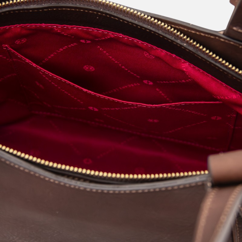 Open brown leather bag showing red fabric interior with stitched pockets and a gold zipper edge (bag interior)