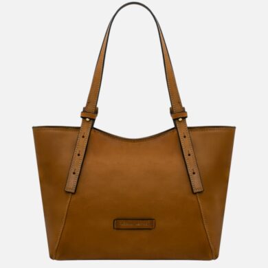 Tan leather tote bag with two long straps and a small front label, empty and standing upright against a light background.
