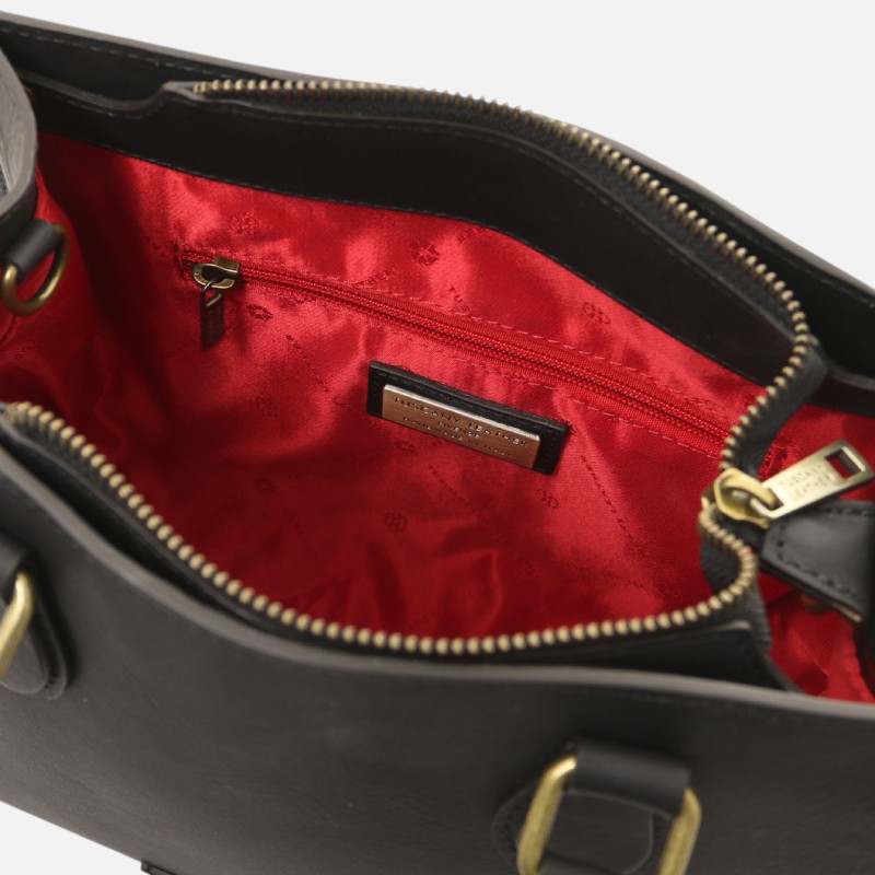 Black handbag opened to reveal red satin interior, inner zip pocket, and a small brand plate on the lining.