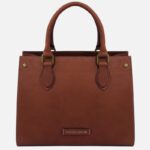 Brown leather handbag with two rounded handles, visible stitching, and a small Tuscany Leather label on the front.
