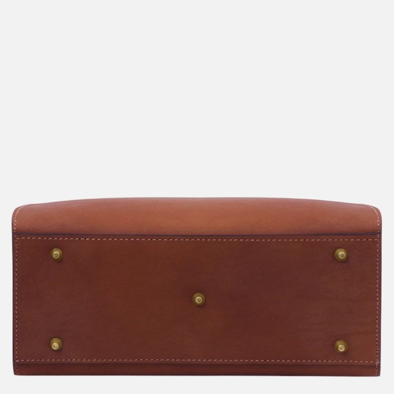 Bottom view of a brown leather handbag with brass studs and stitched edges.