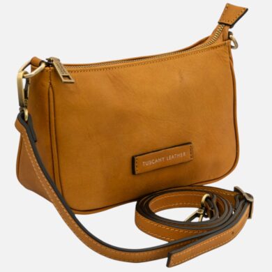 Tan leather crossbody bag with a zip closure and adjustable strap, featuring a front Tuscany Leather patch.