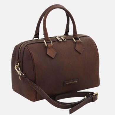 Brown leather handbag with double top handles and a detachable shoulder strap on a light background.