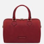 Red leather handbag with two top handles, gold-tone hardware, and a zip closure (front label reads 'Tuscany Leather').