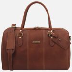 Brown leather briefcase with two top handles, brass hardware, and beige stitching; features a luggage tag and small front plaque.