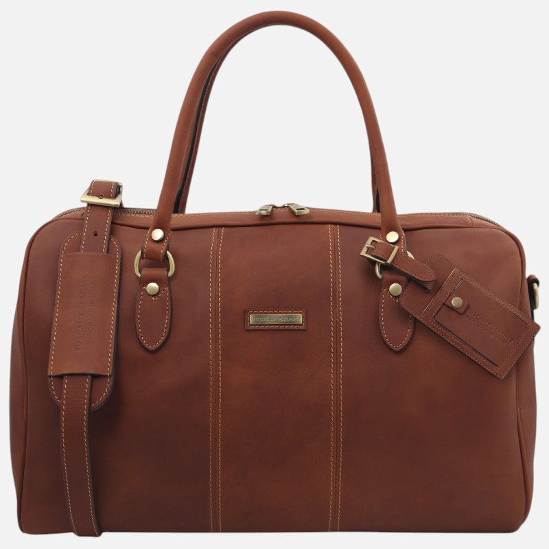 Brown leather briefcase with two top handles, brass hardware, and beige stitching; features a luggage tag and small front plaque.