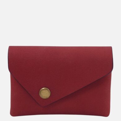 Red envelope-style clutch purse with a brass snap closure on a red surface.