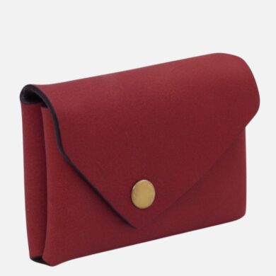 Red leather wallet with a curved flap and a gold snap button on white background.”