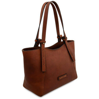 Brown leather tote bag with two shoulder straps and a small brand plaque on the front.
