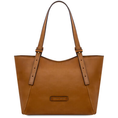 Tan leather tote bag with two long straps and a small front label, empty and standing upright against a light background.