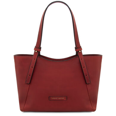 Red leather tote bag with two long straps and a small Tuscany Leather brand patch on the front.