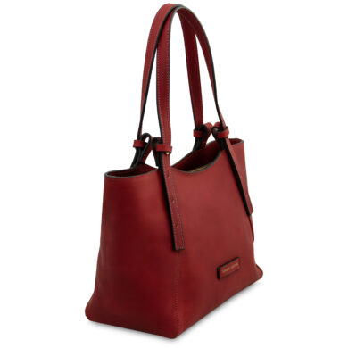 Red leather tote bag with two long handles, stitched edges, and a small front logo plaque