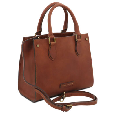 Brown leather tote bag with two top handles and a detachable shoulder strap, brass hardware, and stitched edges.